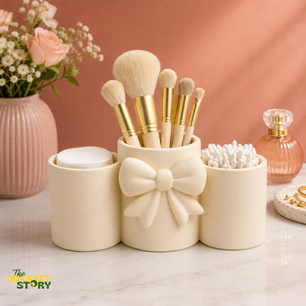 Elegant bow makeup brush holder with compartments for makeup brushes, cotton pads, cotton swabs, and beauty accessories.